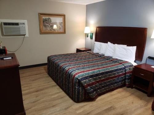 Habitación de hotel con cama y ventilador en River Heights Motel, en Crump