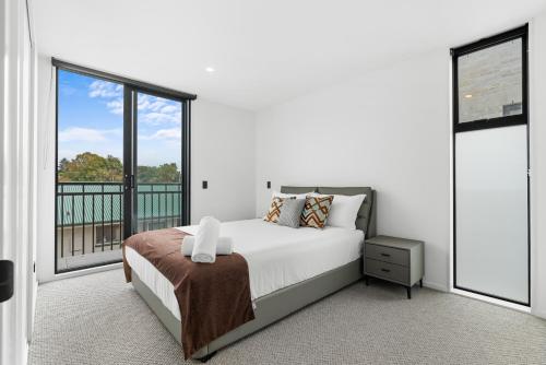 - une chambre blanche avec un lit et une grande fenêtre dans l'établissement Stylish Cosy 2 Bed, à Christchurch