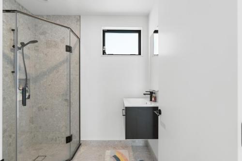 a bathroom with a glass shower and a sink at Stylish Cosy 2 Bed in Christchurch
