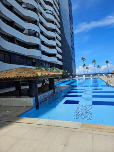 a swimming pool in front of some tall buildings at BEACH FLAT in Salvador