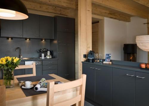 a kitchen with black cabinets and a wooden table at Modernes Holzhaus mit Sauna, Whirlpool und Entspannungsraum in Regen