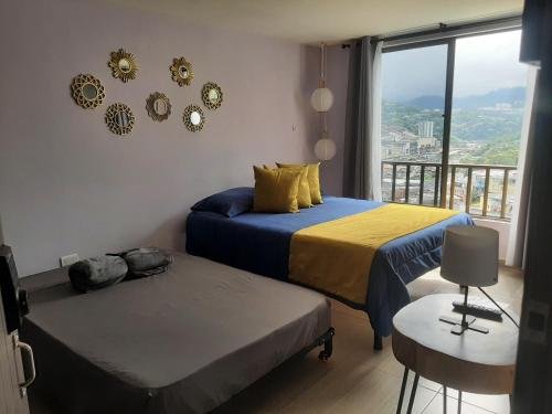 マニサレスにあるSuite con hamaca y baño privado.のベッドルーム1室(ベッド2台付)、景色を望むバルコニーが備わります。