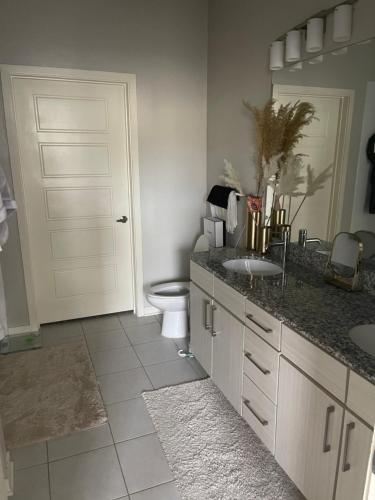 a bathroom with a toilet and a sink and a door at Luxury 2bedroom condo in Fairburn