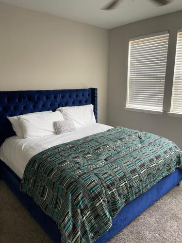a bed with a blue headboard in a bedroom at Luxury 2bedroom condo in Fairburn