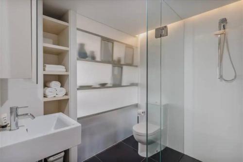 a bathroom with a toilet and a glass shower at Apartment nestled between Lake Burley Griffin, city and ANU in Canberra