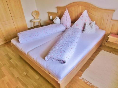 a bed with pink and white pillows on it at Wunderschöne Wohnung in Sigiswang mit Terrasse in Ofterschwang