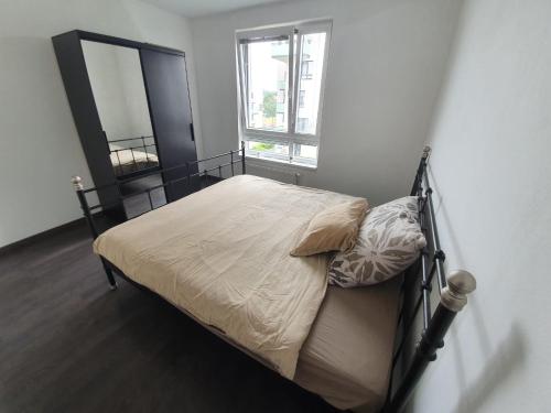 Schlafzimmer mit einem Bett mit einem Spiegel und einem Fenster in der Unterkunft Private, spacious apartement close to city centre in Moravská Ostrava