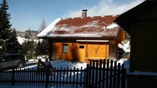 a house with a fence in the snow at Ferienhaus für 5 Personen ca 70 qm in Buchbauer, Kärnten Saualpe in Wiesenau