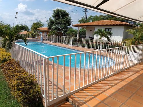 a swimming pool with a fence around it at FINCA LA ALDEA Cabañas campestres in La Tortuga