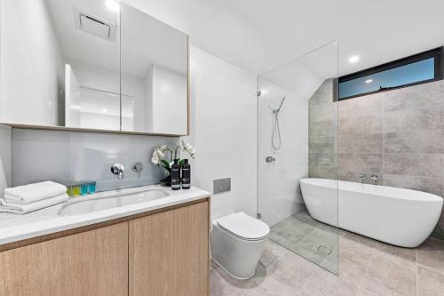 a bathroom with a tub and a toilet and a sink at Luxury Penthouse 3 Bedrooms in Neutral Bay in Sydney