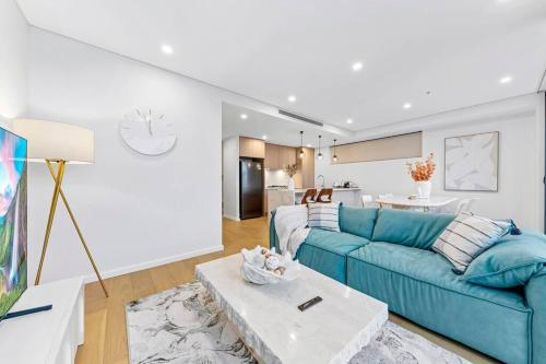 a living room with a blue couch and a table at Luxury Penthouse 3 Bedrooms in Neutral Bay in Sydney