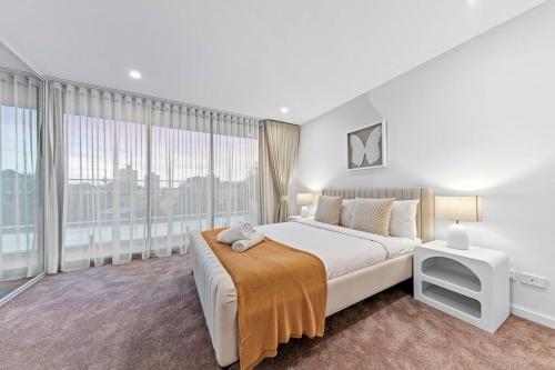 シドニーにあるLuxury Penthouse 3 Bedrooms in Neutral Bayの白いベッドルーム(大きなベッド1台、大きな窓付)