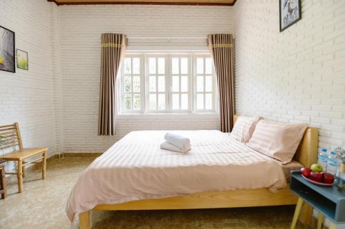 a bedroom with a bed with two towels on it at Scent Villa - Village in Da Lat