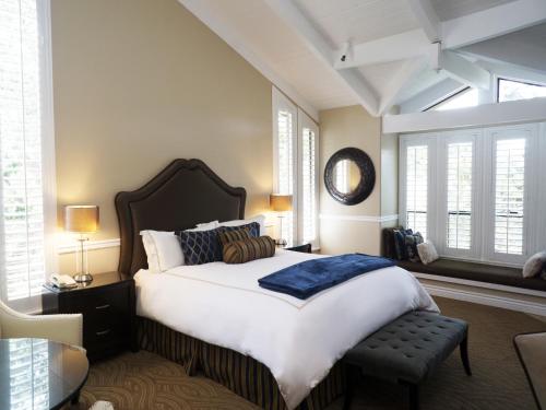 a large bedroom with a large bed and windows at Carriage House Inn in Carmel