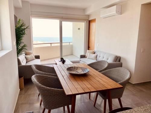 a living room with a table and chairs and a couch at Depto con alberca y Netflix condominio in Conchal