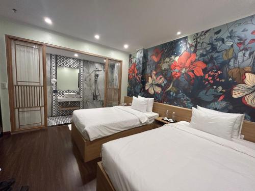 a hotel room with two beds and a painting on the wall at Grand Hotel HN- by BAY LUXURY in Hanoi
