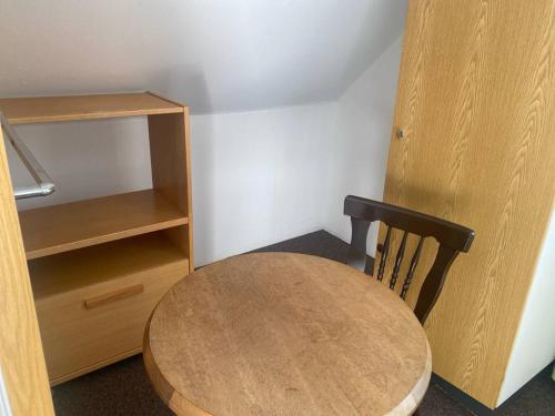 a wooden table and a chair in a room at Room in Guest room - Pension Forelle - double room 001 in Forbach