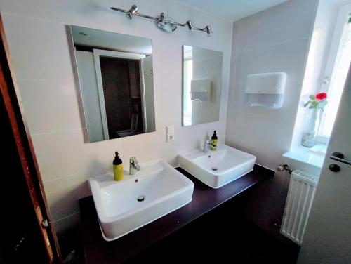 a white bathroom with two sinks and a mirror at Room in Guest room - Pension Forelle - double room 001 in Forbach