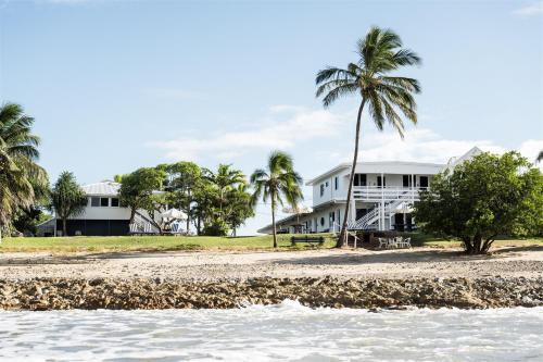 a house on the beach with palm trees and the water at Seaspray Yeppoon in Yeppoon