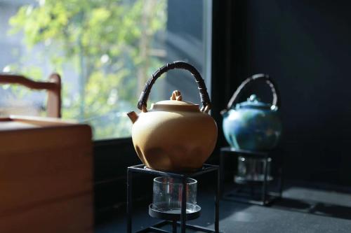 a tea pot and a vase on a table at 北京重构空间酒店天安门王府井店 in Beijing