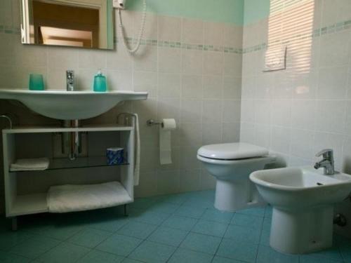 een witte badkamer met een wastafel en een toilet bij Lavanda - Studio-Apartment auf einem Bauernhof im Grünen zwischen Reggio und Modena in Scandiano