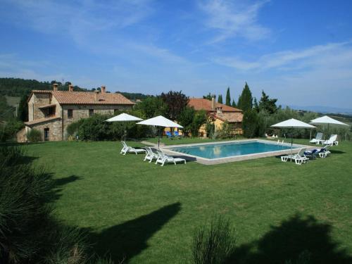 einen Pool mit Stühlen und Sonnenschirmen im Hof in der Unterkunft Belvilla by OYO Casale Nuovo in Chianciano Terme