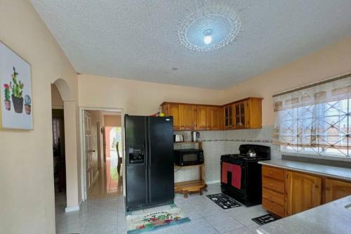 eine Küche mit einem schwarzen Kühlschrank im Zimmer in der Unterkunft Boscobel Hillside Hideaway in Saint Mary