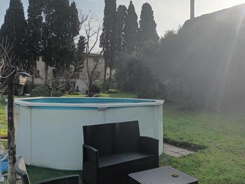 a pool in a backyard with a chair and a table at Luxury Retreat Montevettolini in Montevettolini
