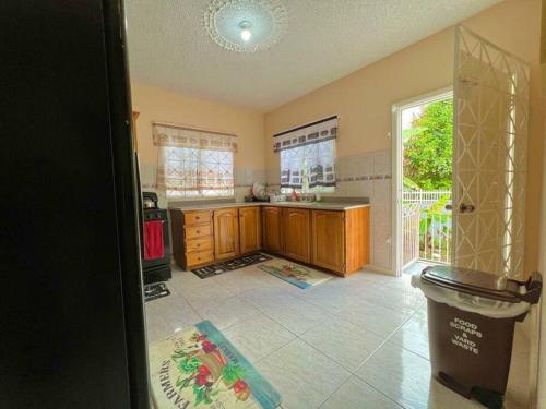 a kitchen with wooden cabinets and an open door at Boscobel Hillside Hideaway in St Mary