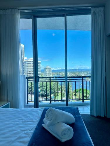 a bedroom with a large window with towels on a bed at Chevron Renaissance - Resort Style Living by Gold Coast Premium in Gold Coast