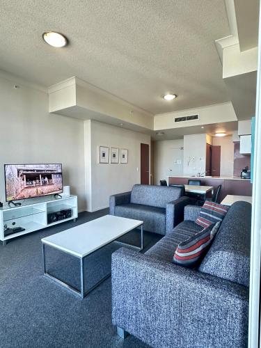 a living room with couches and a flat screen tv at Chevron Renaissance - Resort Style Living by Gold Coast Premium in Gold Coast