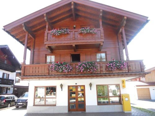 un edificio con un balcón con flores. en Gemütliche Ferienwohnung mit Balkonen, direkt im Ortszentrum von Reit im Winkl, en Reit im Winkl