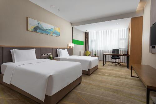 a hotel room with two beds and a desk at Holiday Inn Chengdu Airport, an IHG Hotel in Chengdu