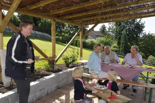 a group of people sitting at a table in a garden at Boutique Hotel Angerer in Murnau am Staffelsee