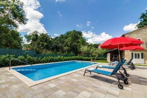 basen z czerwonym parasolem, krzesłem i czerwonym parasolem w obiekcie Villa Zoro mit schönen Garten und privatem Pool w mieście Pazin