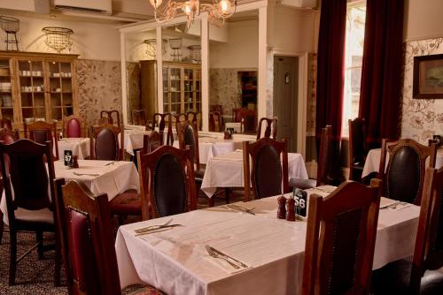 a restaurant with white tables and chairs and a chandelier at Yarra Valley Grand in Yarra Glen