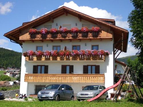 uma casa com uma varanda com flores em Wohnung in Meransen em Maranza