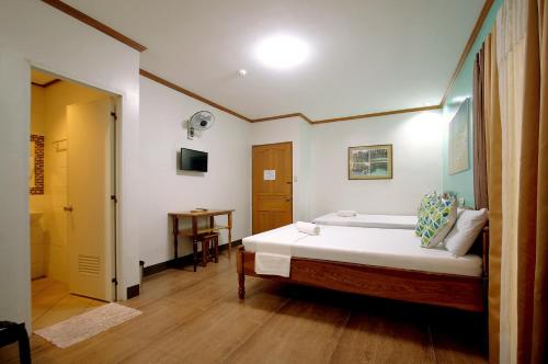 a bedroom with a large bed and a bathroom at ISLANDS VIEW INN in Coron