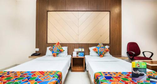 a room with two beds and a table and a chair at Hotel Park Resort Bhubaneswar Couple Friendly in Bhubaneshwar