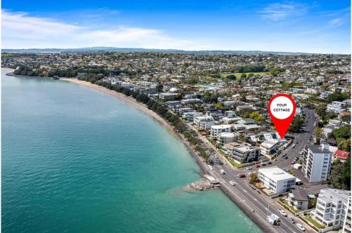 an aerial view of a beach with a red marker at Escape to Kohi Cottage - Your Beachside Haven in Auckland