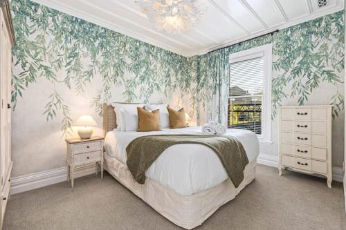 um quarto com uma cama grande e papel de parede floral em 3BR Boutique Villa Walk to SPARK Arena w Parking em Auckland