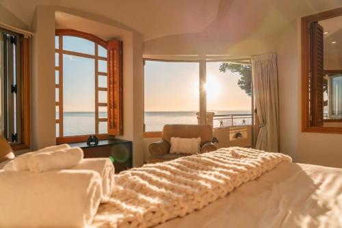 奧克蘭的住宿－Takapuna Beachfront w Stunning Views，一间卧室设有一张床,享有海景