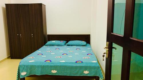 1 dormitorio con 1 cama con edredón azul en VILLA 81/3, en Matara