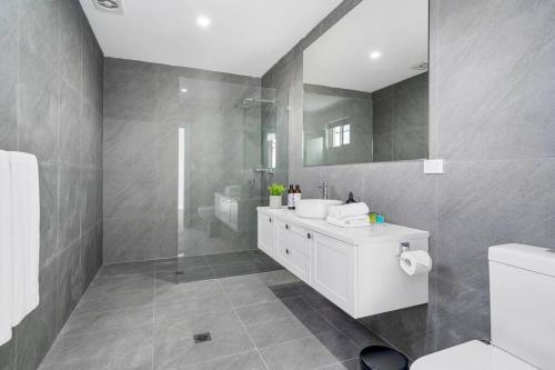 a bathroom with a white sink and a mirror at King’s Deluxe in Newtown in Sydney