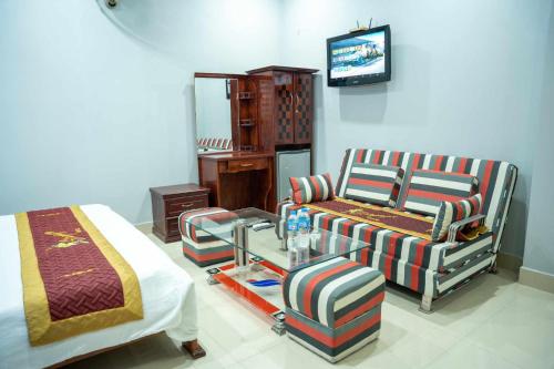 a bedroom with a bed and a couch and a chair at Stargazerhotel Đà Nẵng- Khách sạn Hoa Ly in Da Nang