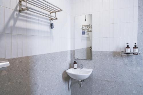 ein Bad mit einem Waschbecken und einem Spiegel in der Unterkunft Brownies House in Bandung
