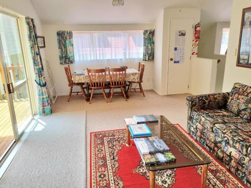 un soggiorno con divano e tavolo di Arles Historical Homestead a Whanganui