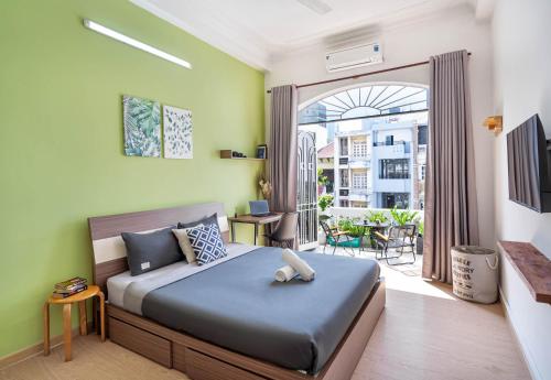 a bedroom with a bed and a balcony at HoLo Fairy House Saigon - Serviced Homestay in Ho Chi Minh City