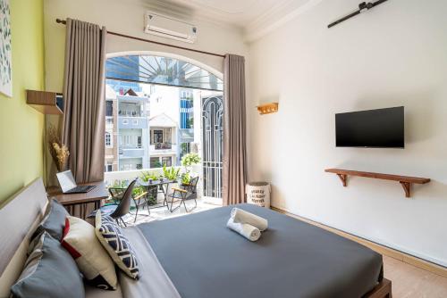- une chambre avec un lit et une grande fenêtre dans l'établissement HoLo Fairy House Saigon - Serviced Homestay, à Hô-Chi-Minh-Ville