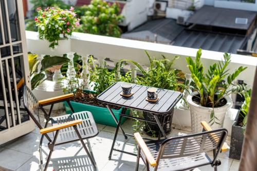 a table and chairs on a balcony with plants at HoLo Fairy House Saigon - Serviced Homestay in Ho Chi Minh City